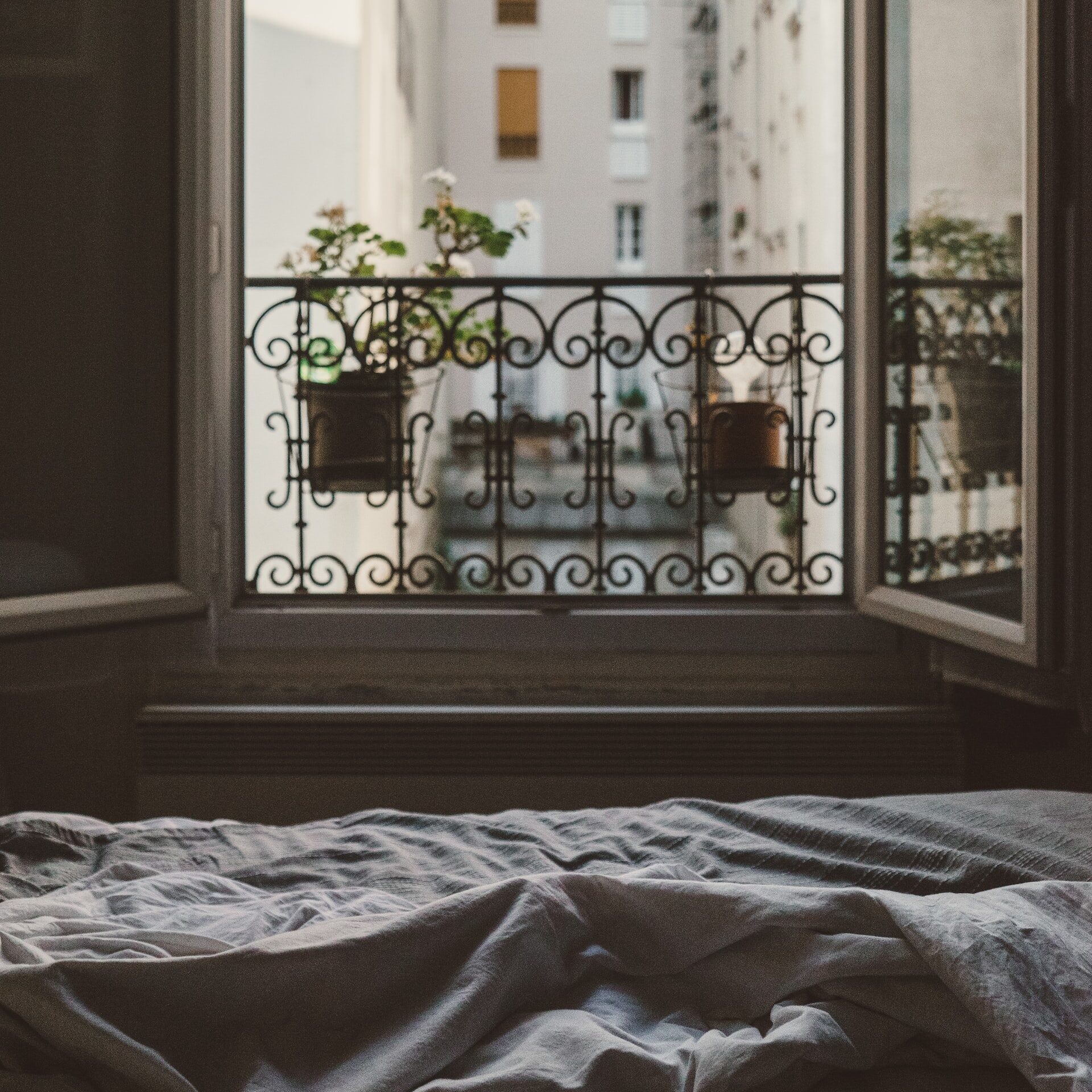 Open balcony view from unmade bed.